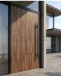 Puerta pivotante de aluminio con laminado de alta presión en nogal.